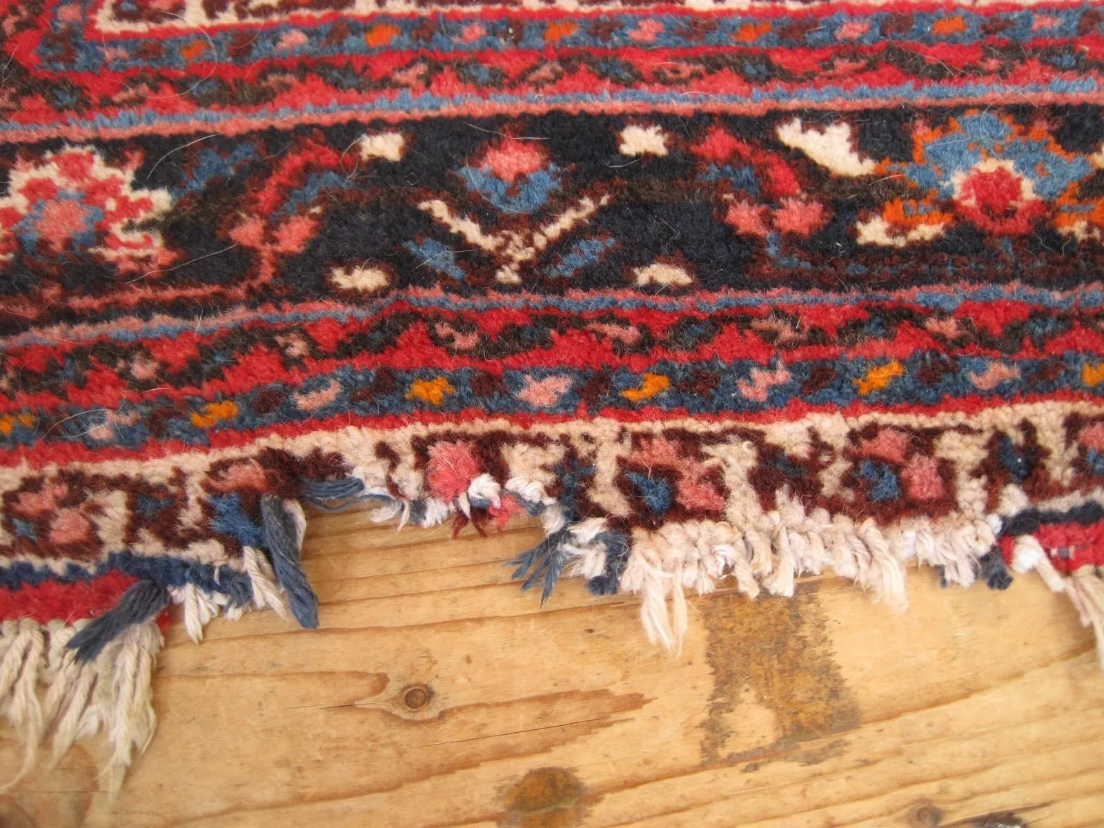 Persian rug with damaged fringes before repair